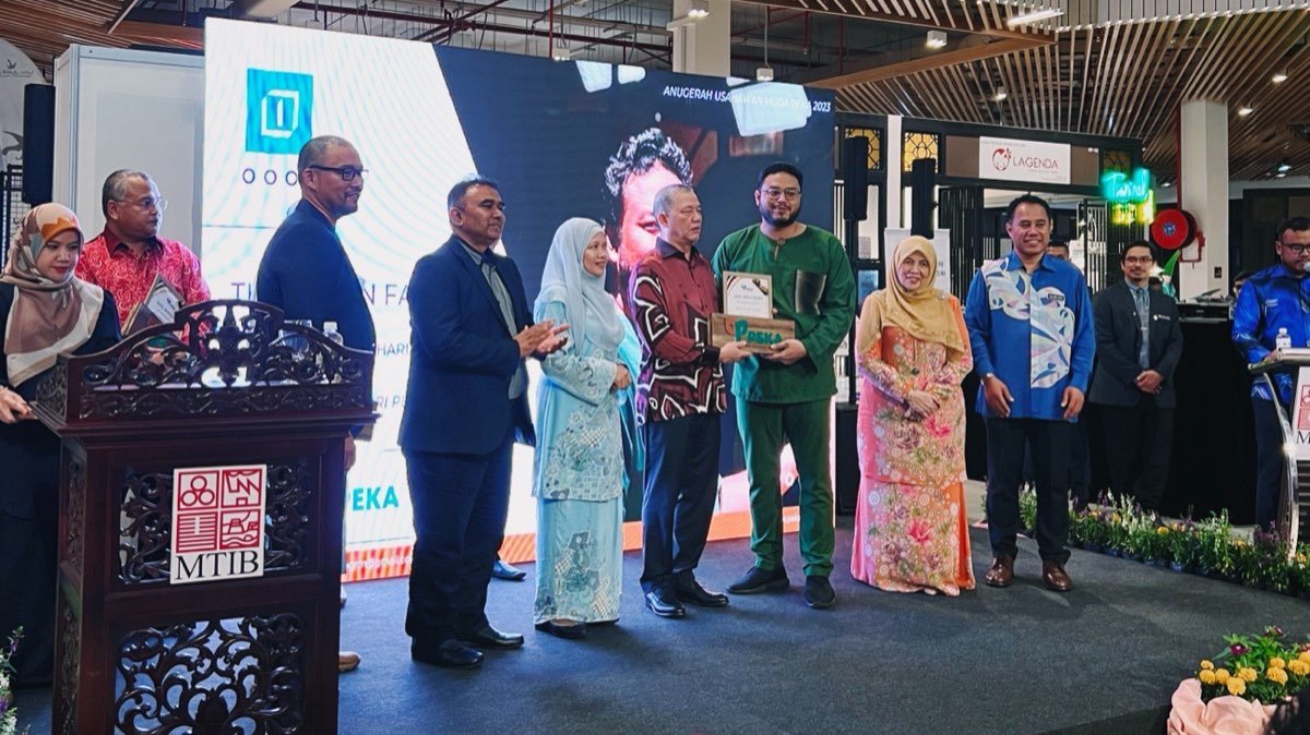 Harith menerima anugerah di pentas.